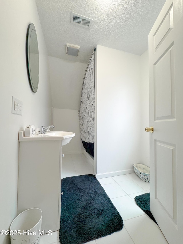 bathroom featuring tile patterned floors, vanity, and a textured ceiling