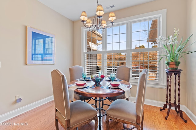 dining room featuring a notable chandelier and light wood-type flooring