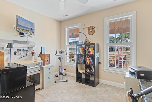 exercise room with ceiling fan and light colored carpet