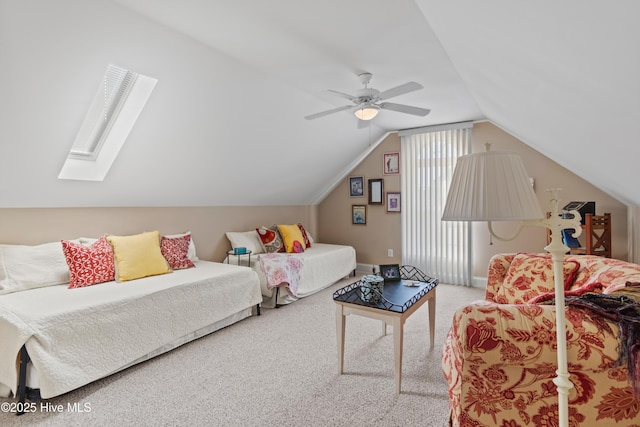 bedroom featuring lofted ceiling with skylight, carpet, and ceiling fan