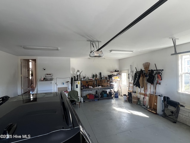 garage with a garage door opener and a workshop area