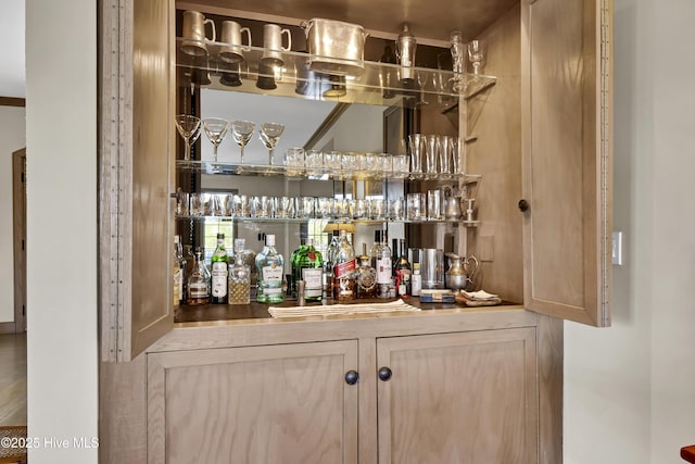 bar with light brown cabinetry