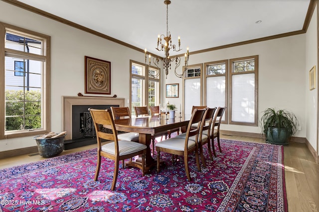 dining room with a notable chandelier, crown molding, and hardwood / wood-style flooring