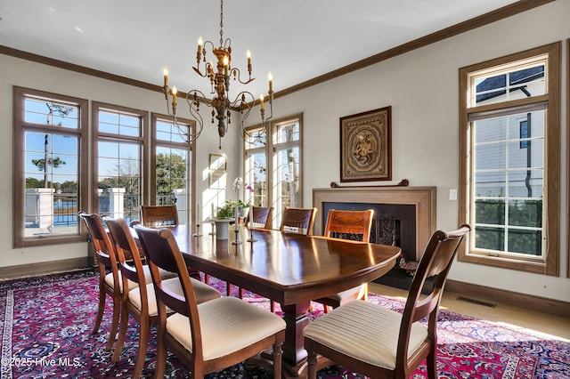 dining space with ornamental molding and an inviting chandelier