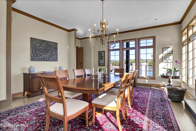 dining room with ornamental molding, wood-type flooring, and an inviting chandelier