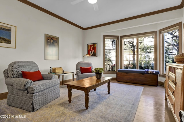 living area featuring ornamental molding, wood-type flooring, and ceiling fan