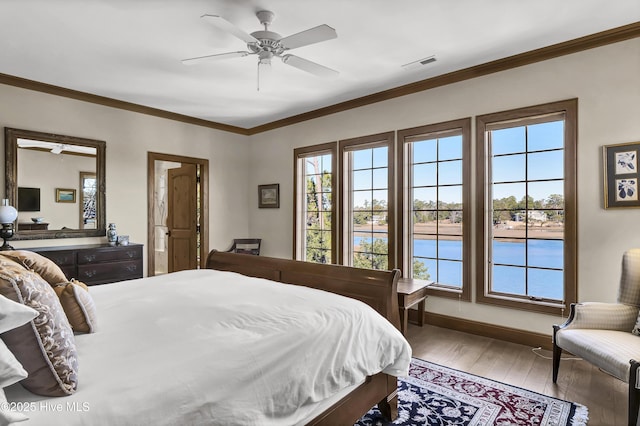 bedroom with ceiling fan, ornamental molding, and wood-type flooring