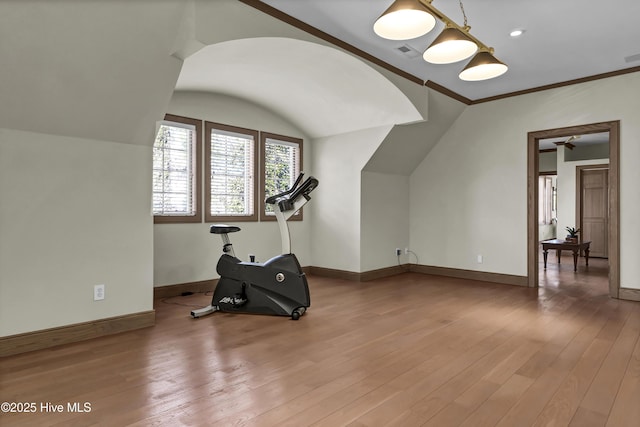 workout room featuring hardwood / wood-style flooring, lofted ceiling, and crown molding