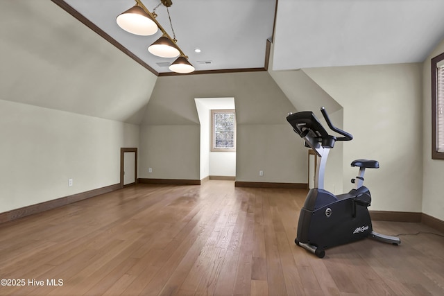 workout area with vaulted ceiling and hardwood / wood-style floors