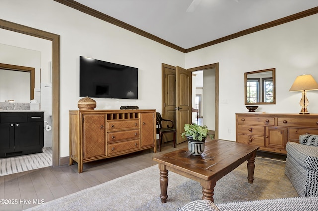 living room with crown molding, sink, and light hardwood / wood-style flooring