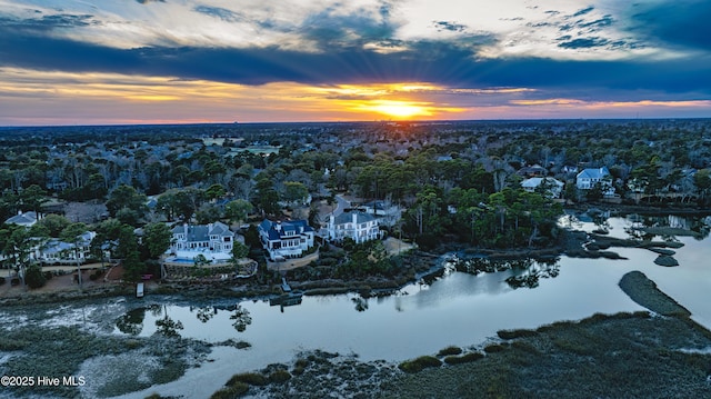 aerial view at dusk featuring a water view