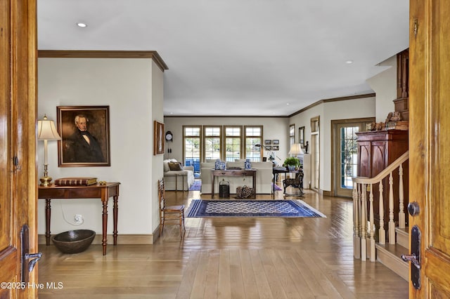 foyer entrance with ornamental molding and hardwood / wood-style floors