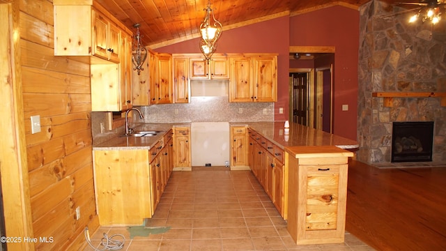 kitchen with vaulted ceiling, decorative light fixtures, tasteful backsplash, sink, and light brown cabinets