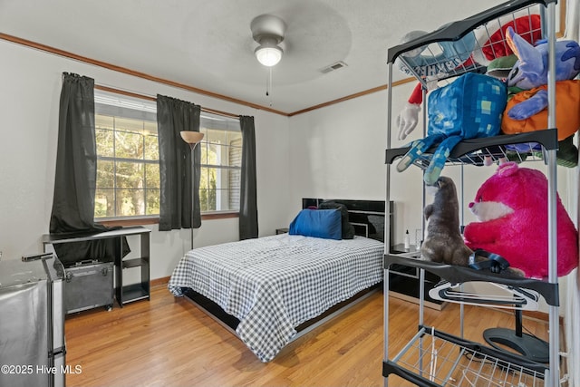 bedroom with hardwood / wood-style floors, crown molding, a textured ceiling, and ceiling fan