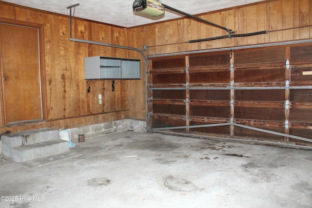 garage with a garage door opener and wood walls