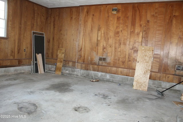 interior space featuring concrete floors and wood walls