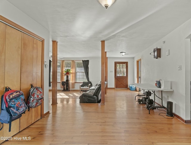 entrance foyer with decorative columns and light hardwood / wood-style floors