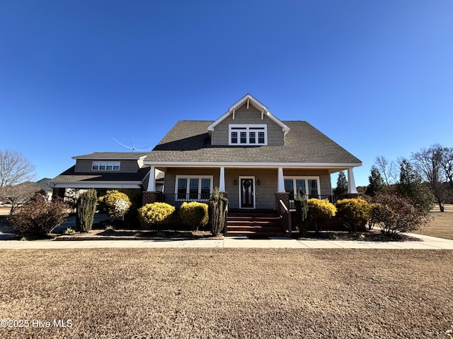 view of front of home featuring covered porch and a front lawn