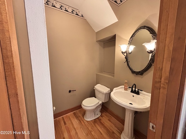 bathroom with hardwood / wood-style flooring, lofted ceiling, and toilet