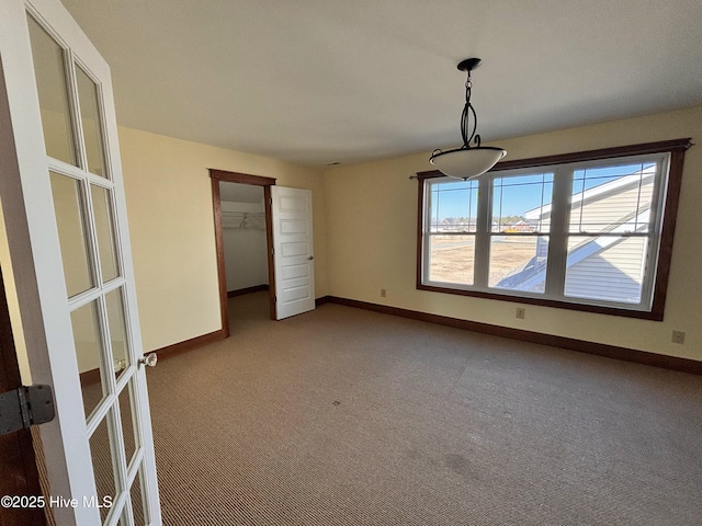 unfurnished dining area featuring french doors and carpet