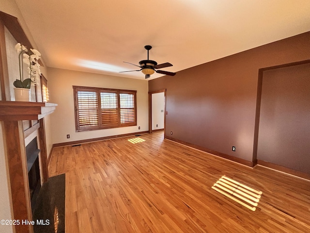 unfurnished living room with ceiling fan and light wood-type flooring