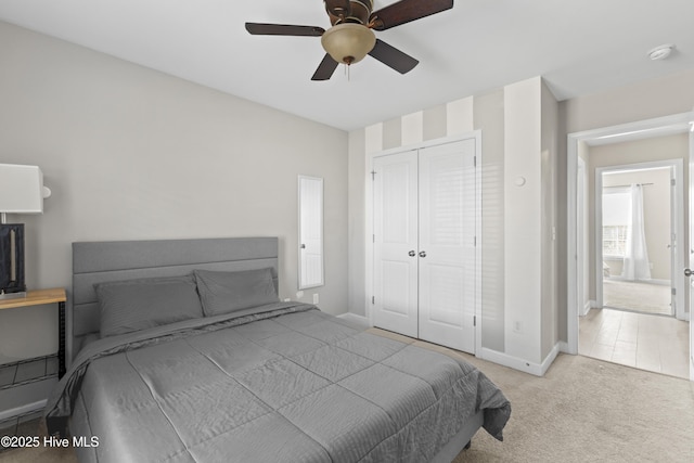 bedroom featuring light colored carpet, a closet, and ceiling fan