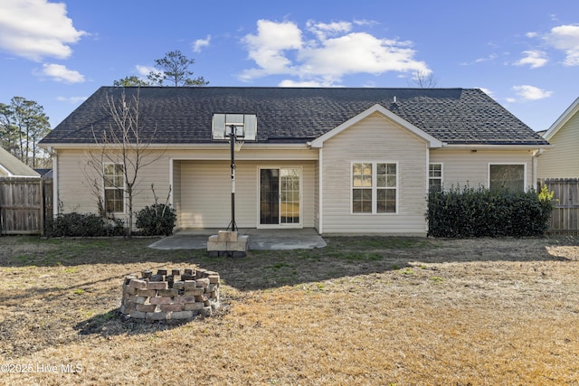 back of house with a yard, a patio area, and a fire pit