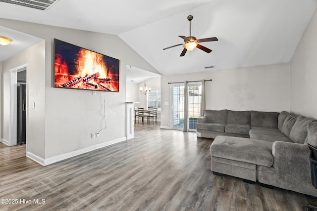 living room with vaulted ceiling, ceiling fan with notable chandelier, and hardwood / wood-style floors