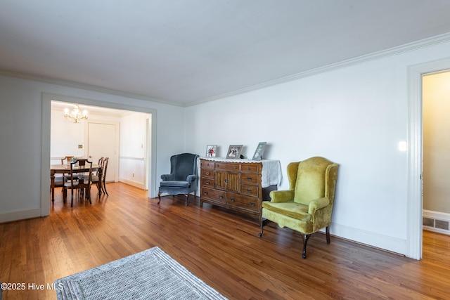 sitting room featuring ornamental molding, dark hardwood / wood-style floors, and a chandelier