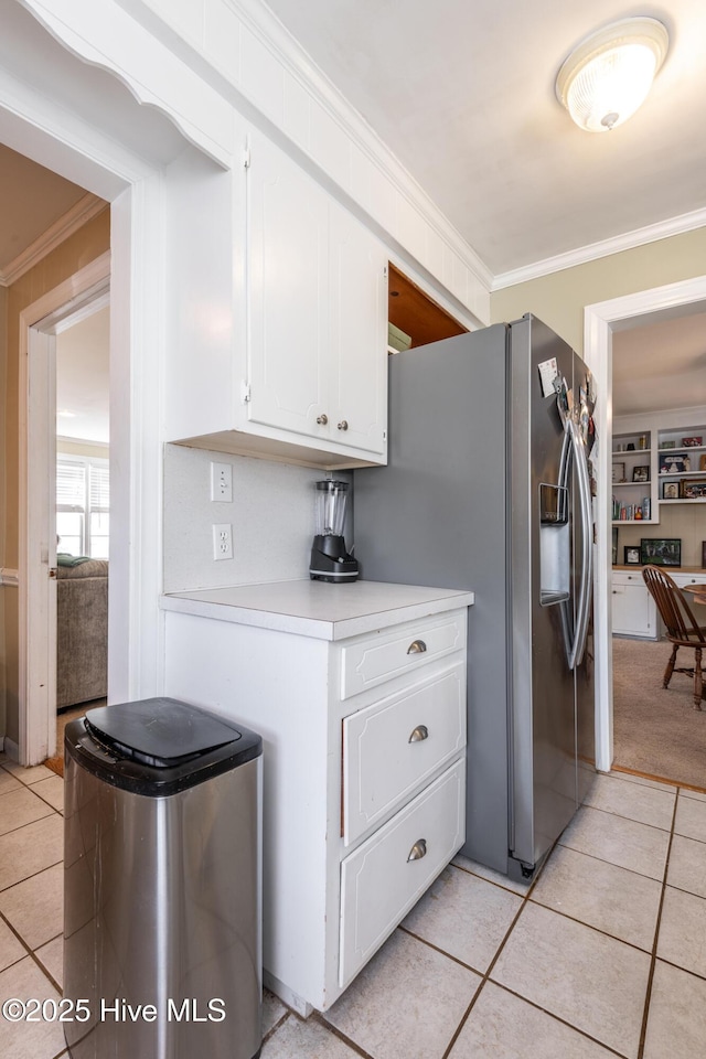 kitchen with white cabinetry, stainless steel fridge, and light tile patterned floors