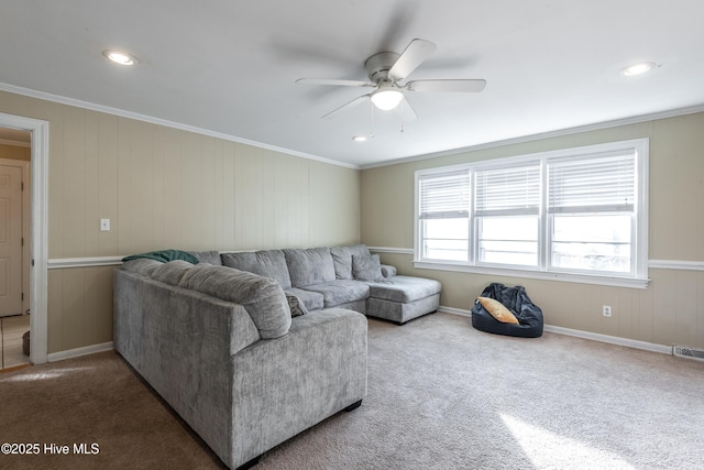 living room with ornamental molding, ceiling fan, and carpet flooring