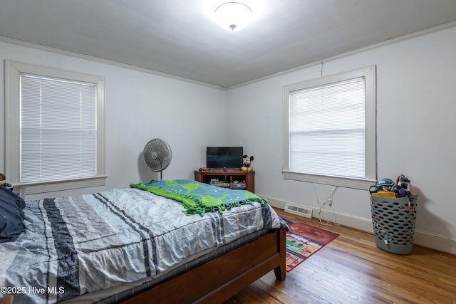 bedroom featuring hardwood / wood-style flooring and ornamental molding