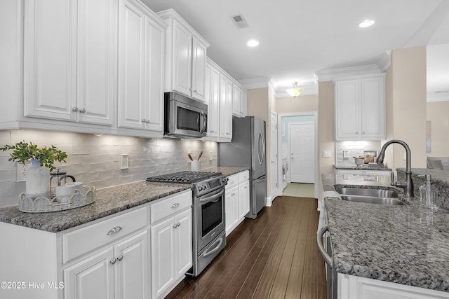 kitchen with sink, ornamental molding, stainless steel appliances, and white cabinets