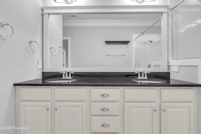 bathroom with vanity, crown molding, and a shower with door