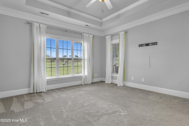 unfurnished room with crown molding, light colored carpet, a raised ceiling, and ceiling fan