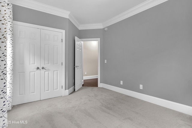 unfurnished bedroom with crown molding, light colored carpet, and a closet