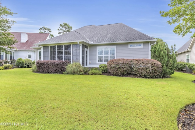 rear view of property featuring a sunroom and a yard