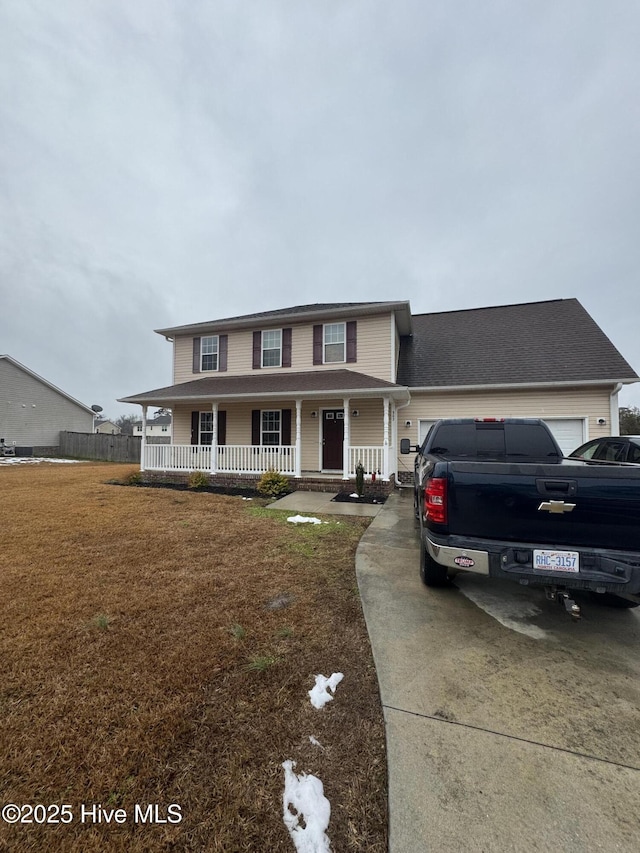 view of front of house featuring a garage, a front yard, and covered porch