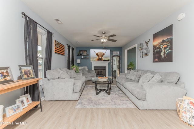 living room with ceiling fan and light wood-type flooring