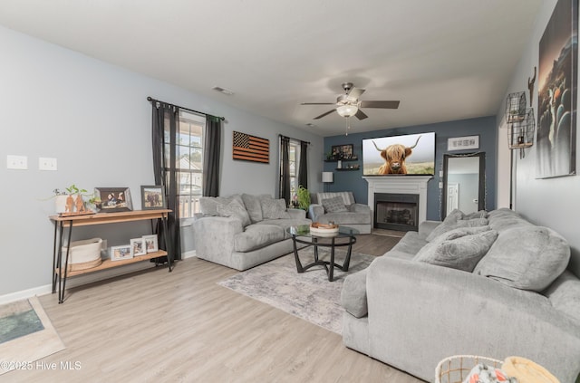 living room featuring ceiling fan and light wood-type flooring