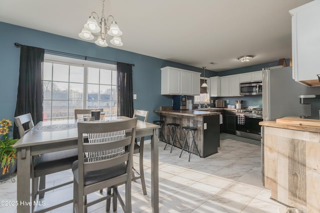 dining space with sink and a notable chandelier