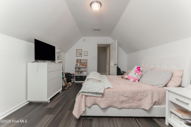 bedroom with dark wood-type flooring and lofted ceiling