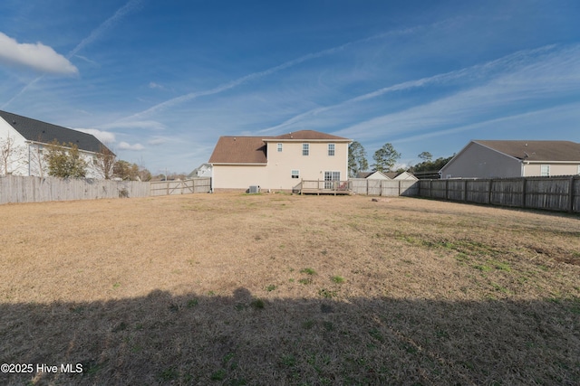 back of house featuring a deck and a lawn