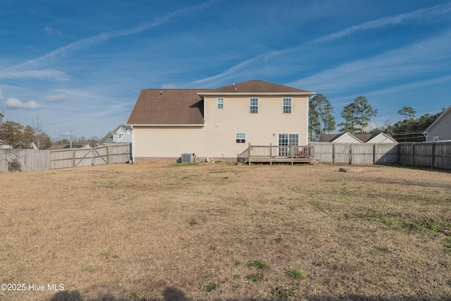 back of house featuring central AC unit, a lawn, and a deck