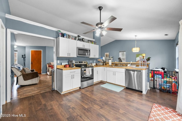 kitchen with dark hardwood / wood-style floors, pendant lighting, white cabinetry, sink, and stainless steel appliances