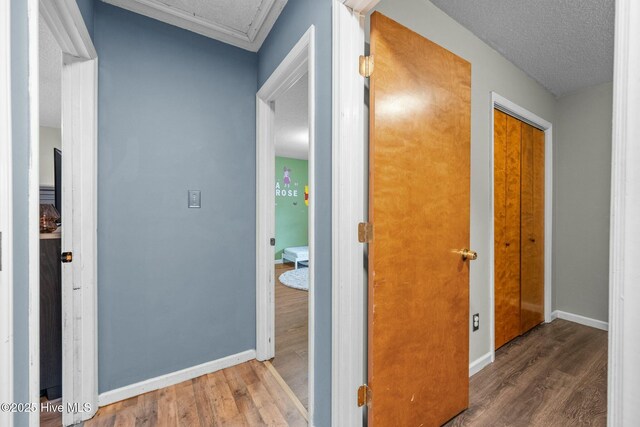 hallway with hardwood / wood-style floors and a textured ceiling