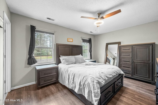 bedroom featuring ceiling fan, dark hardwood / wood-style flooring, and a textured ceiling