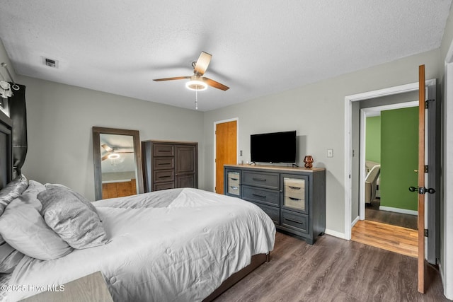 bedroom with ceiling fan, dark hardwood / wood-style flooring, and a textured ceiling