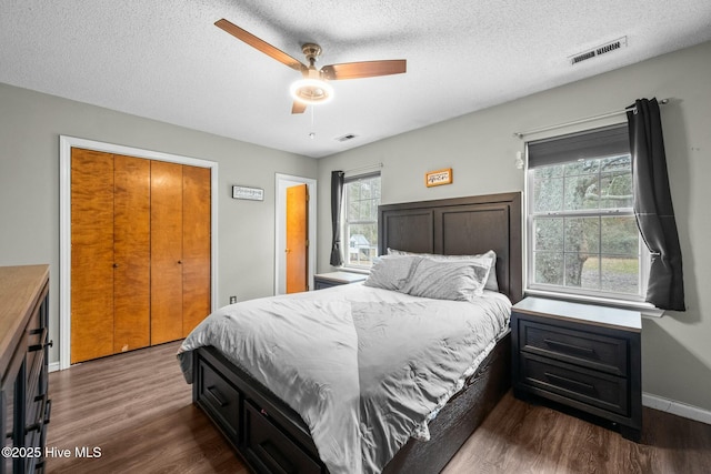 bedroom featuring ceiling fan, dark wood-type flooring, and a textured ceiling