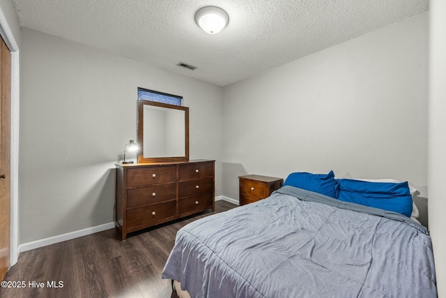 bedroom featuring dark wood-type flooring, a closet, and a textured ceiling